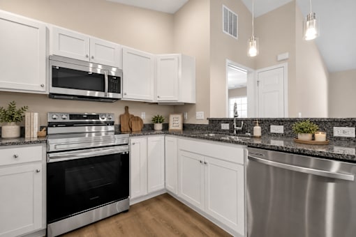 A modern kitchen with white cabinets and stainless steel appliances.