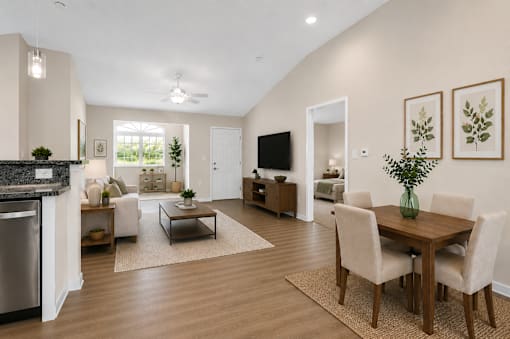 A dining area with a table and four chairs open to a living room area.