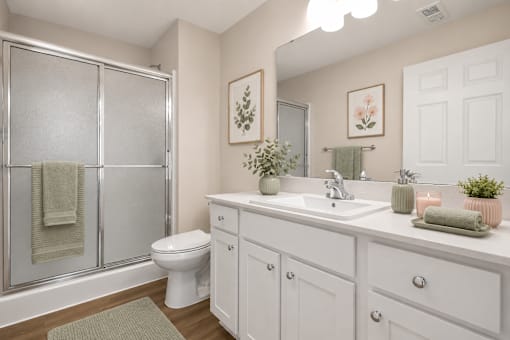 A white bathroom with a toilet, sink, and shower.