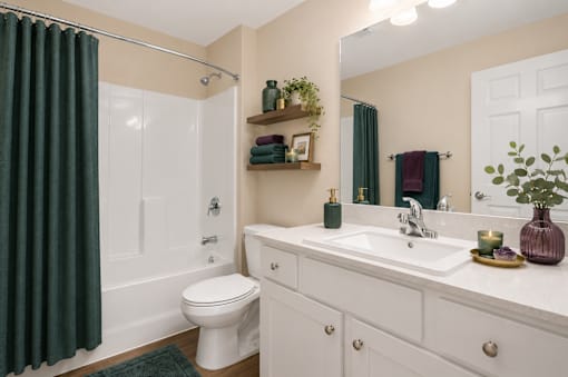 A white bathroom with a toilet, sink, and bathtub..