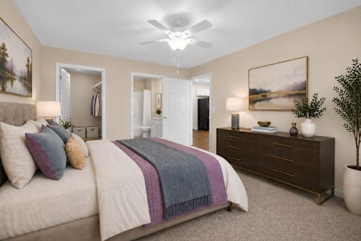 A bedroom with a bed, dresser, and ceiling fan.