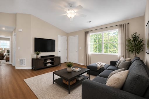 A living room with couch , coffee table, tv and entertainment stand.