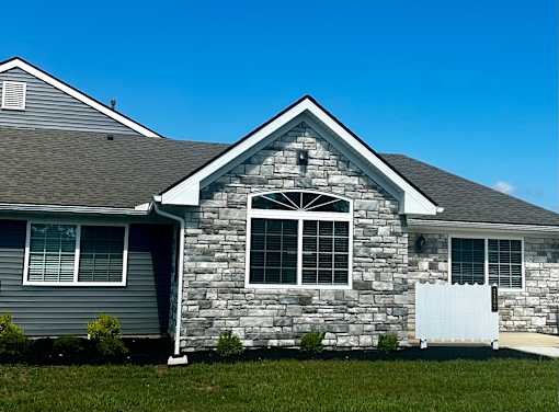 a stone house with a white fence in front of it