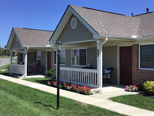 A house with a white porch and a red door.