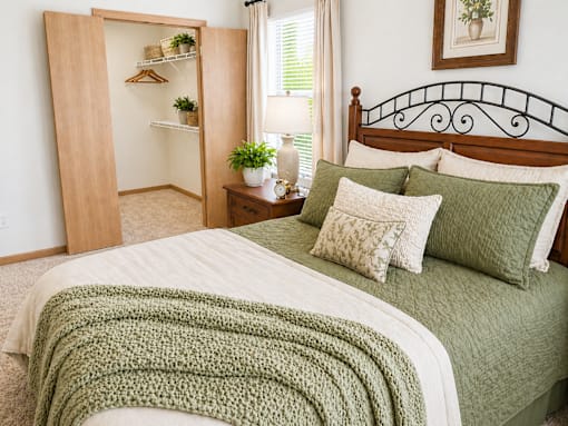 A bedroom with a bed, a nightstand, and a wardrobe.