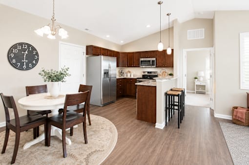 A kitchen with a table and chairs in the middle of the room.