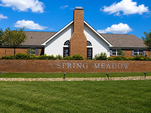 Spring Meadow is a residential area with a brick house and a white fence.