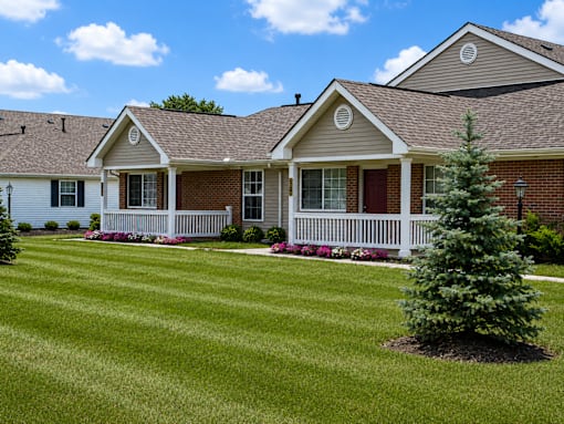 A house with a white fence and a green lawn.