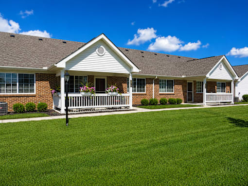 A house with a white porch and a brown roof.