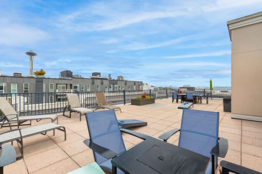 a rooftop patio with chairs and tables and a view of the ocean