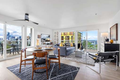 an open concept living room and dining room with a table and chairs and a couch and a