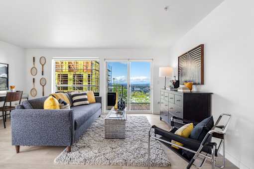 a living room with a gray couch and yellow pillows
