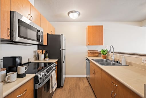 A kitchen with wooden cabinets and a black stove top oven.