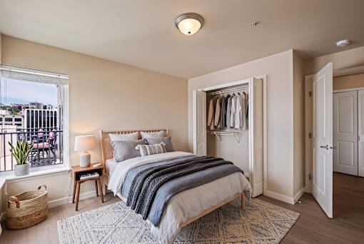 A bedroom with a large bed and a view of the city.