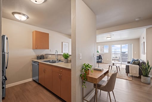 A kitchen with a refrigerator, sink, and wooden cabinets.
