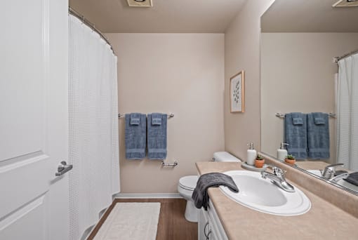 A bathroom with a white sink and a white toilet.