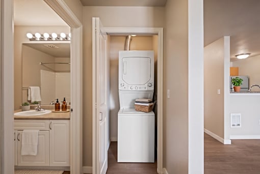 A white washing machine is in a small laundry room.