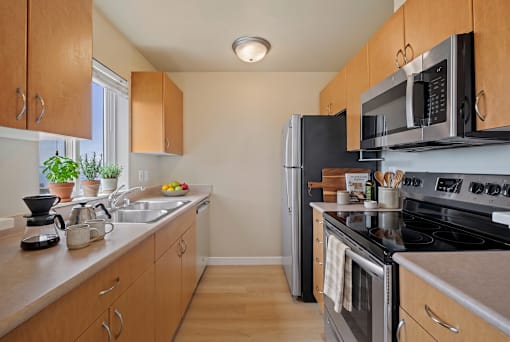 A kitchen with wooden cabinets and a black stove top oven.