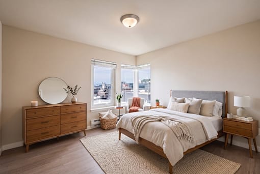 A bedroom with a large bed, a dresser, and a mirror.