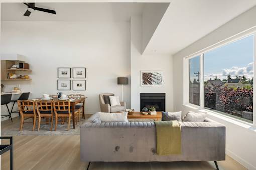 a view of the living room and dining area of a house with a large window