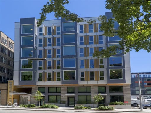 a tall blue building with a street in front of it
