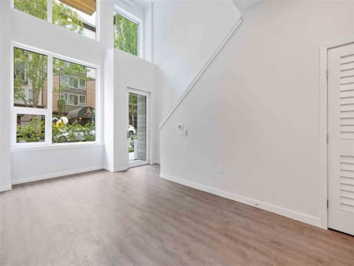 a living room with white walls and a door to a balcony