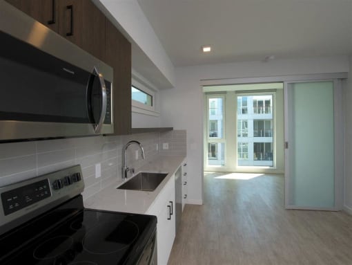 a kitchen with a stove and a sink and a window