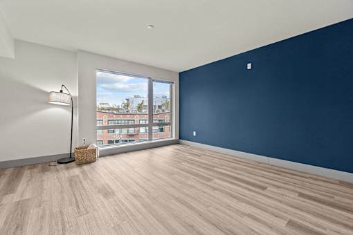 A room with a blue wall and a window overlooking a cityscape.