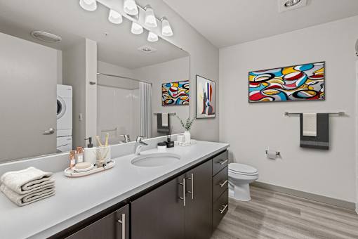 A bathroom with a white counter top and a white toilet.