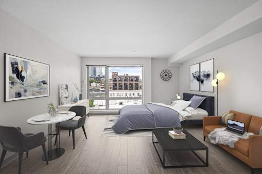 A modern bedroom with a large bed, a couch, a table, and a view of the city.
