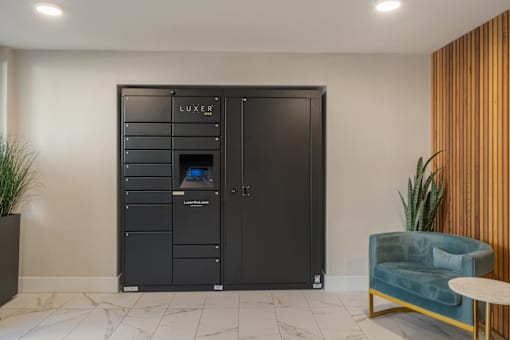 A black LUXER wardrobe with a mirror and a blue chair in front of it.