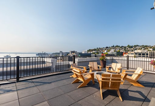 A balcony with chairs and a view of the city.