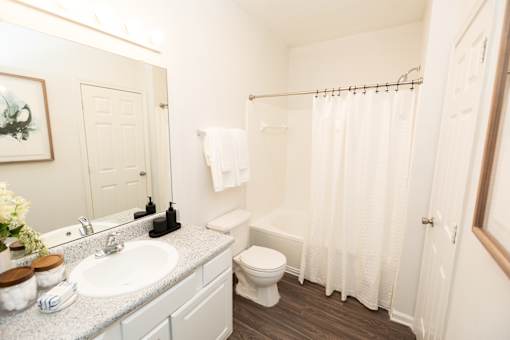 A white bathroom with a toilet, sink, and shower. at Lakeside Villas, Hampton