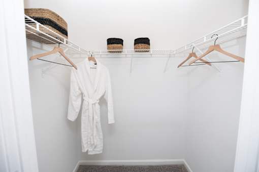 A white robe is hanging on a hanger in a white closet. at Lakeside Villas, Hampton, GA