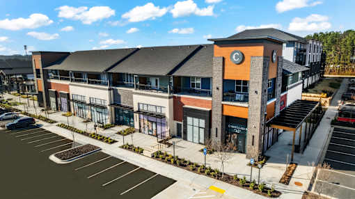 A modern building with a parking lot in front.