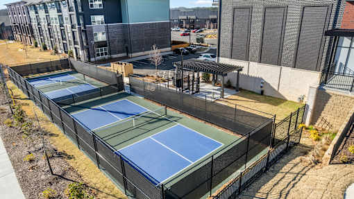 Tennis courts surrounded by a fence.