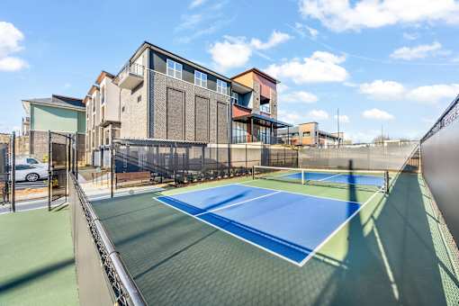 A tennis court is located in front of a building.