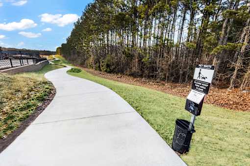 A white sign on a black pole indicates a pet walking area.