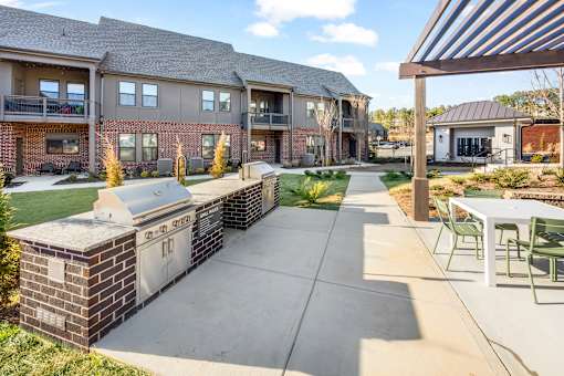 A sunny day at a residential complex with a walkway and greenery.