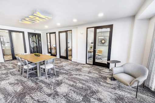 A modern dining room with a wooden table and grey chairs.