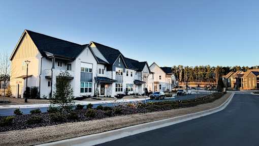 A row of houses with a road in front of them.