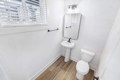 A white toilet and sink in a small bathroom.