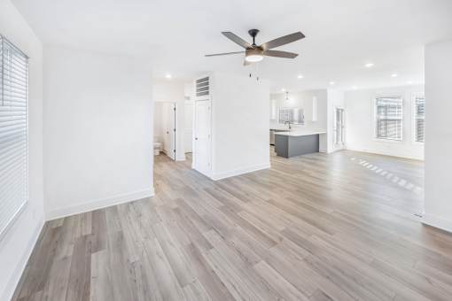 A room with a ceiling fan and wooden flooring.