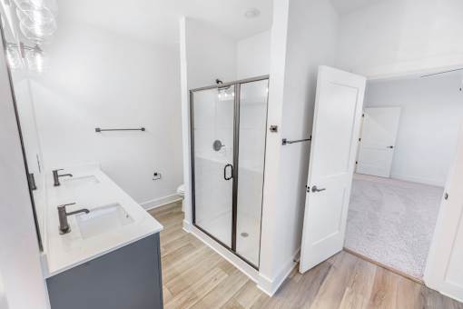 A bathroom with a sink, mirror, and shower.