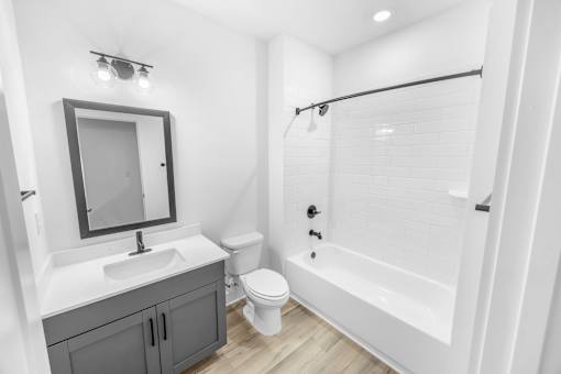 A white bathroom with a sink, toilet, and bathtub.