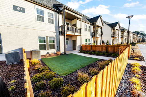 A row of houses with a yellow fence in front.