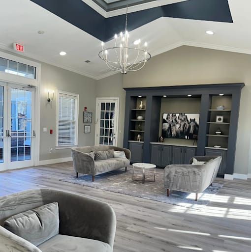 Clubhouse with a grey couch and a chandelier. at The Dawson Cartersville in Cartersville, GA 30191