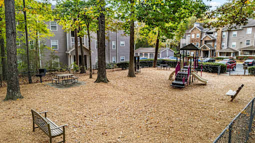 a playground with a slide and benches in a park