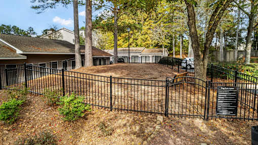 a yard with a fence and a house behind it