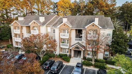 A large apartment building with a parking lot in front.